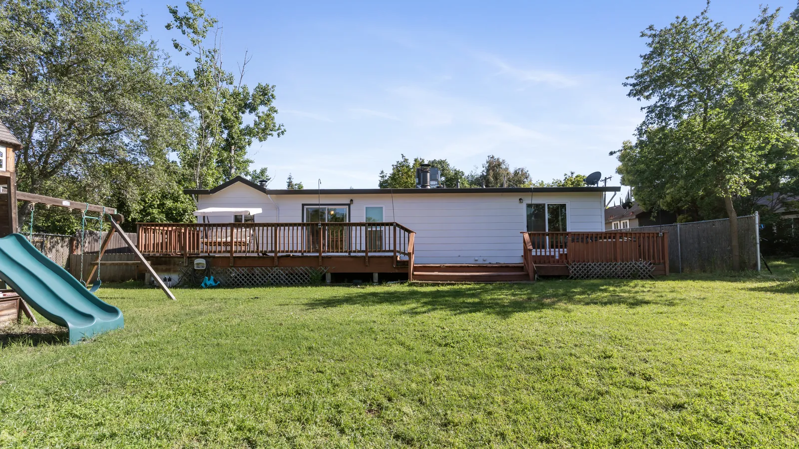 Before: open lawn and the plain back of the house with an old wood deck