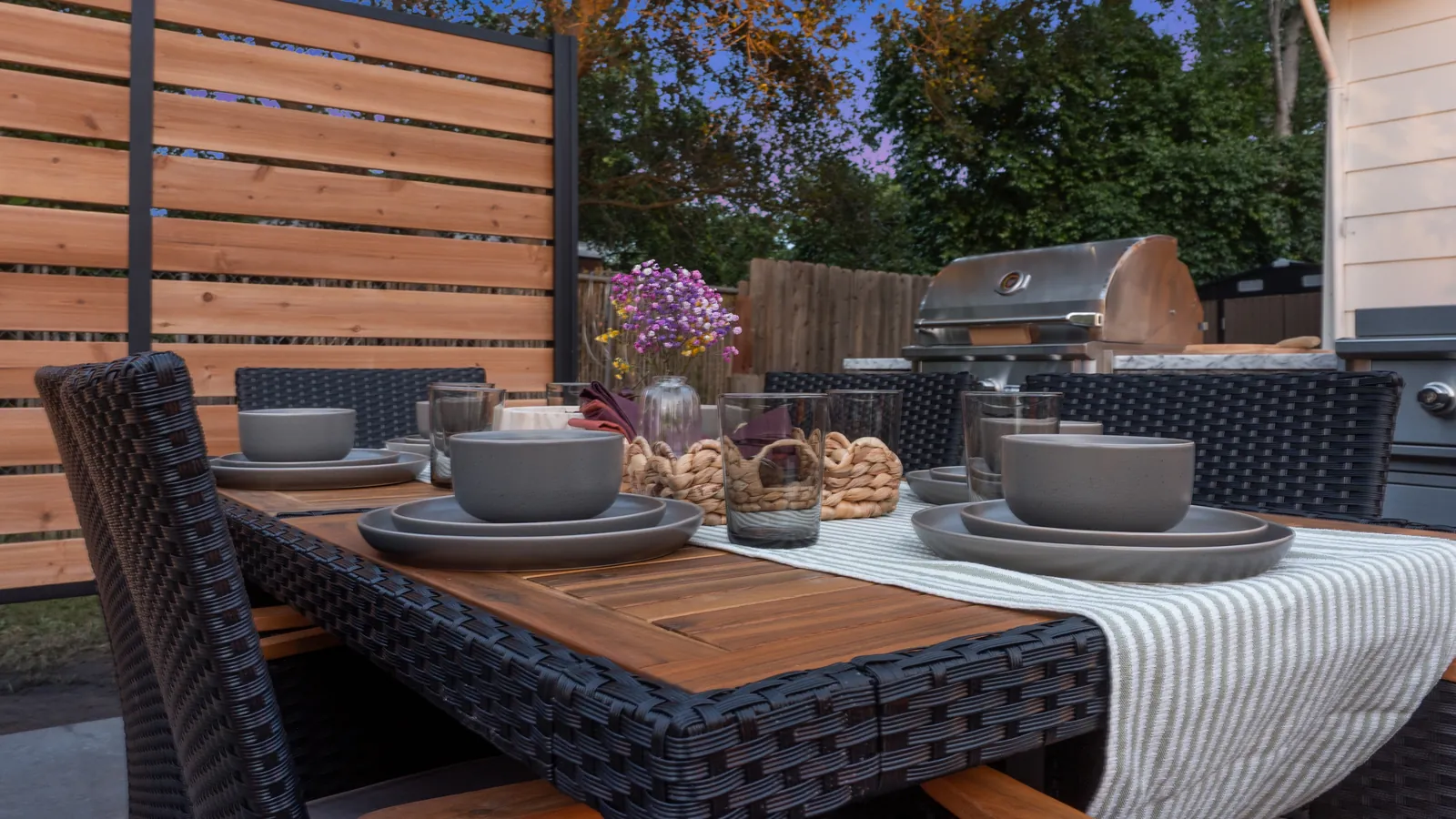Set outdoor dining table with the grill station behind it