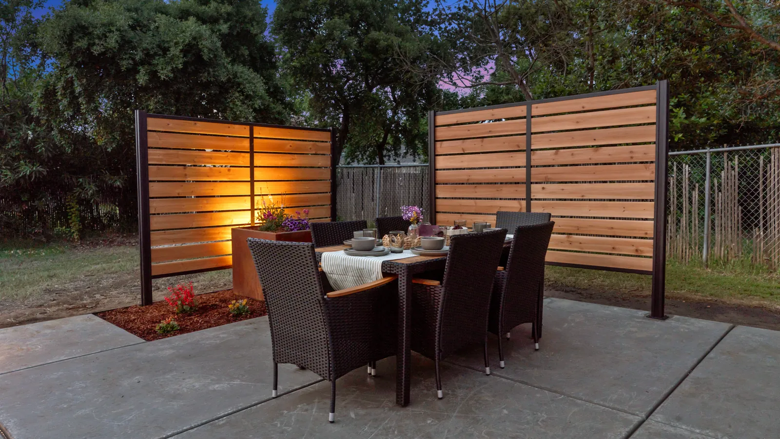 Dining table on the patio between two cedar slat privacy screens