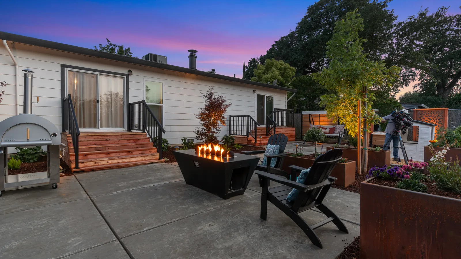 Rectangular fire table with Adirondack chairs in front of new redwood steps at dusk