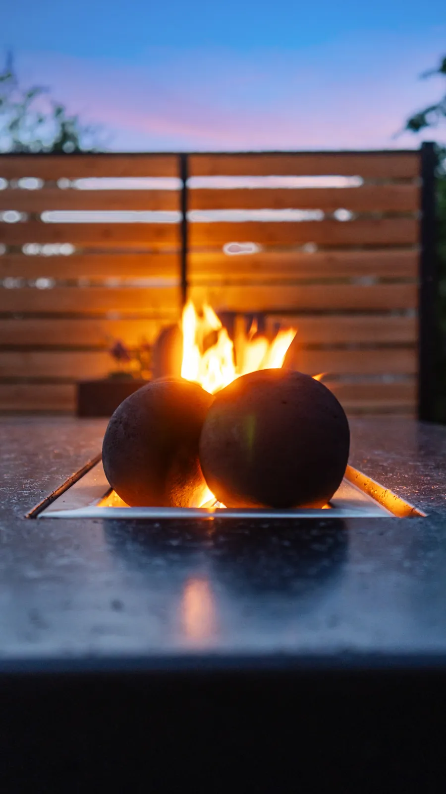 Close-up of fire bowls burning on a dark fire table
