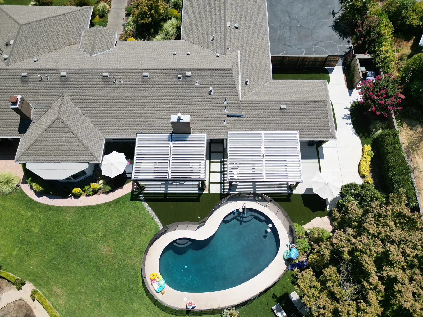 Aerial view of backyard with artificial turf, patio, and pergola in Sacramento